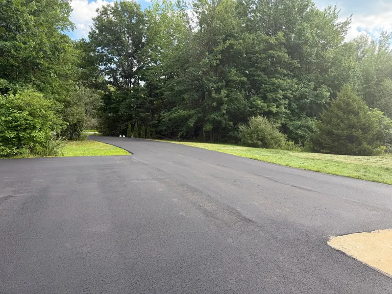 Wide new asphalt turnaround surrounded by trees